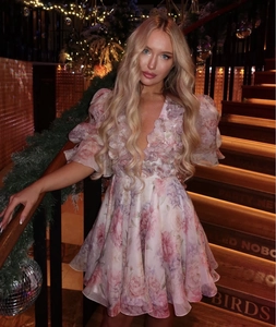 Close-up of pink floral dress with 3D petal decorations and ruffled organza layers