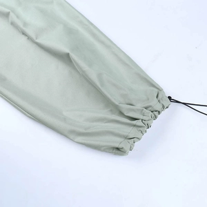 Détail du pantalon cargo vert sauge avec un ourlet à cordon de serrage élastique réglable