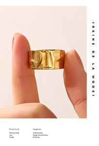 Macro shot of gold wide ring featuring irregular hammered lava texture and glossy finish