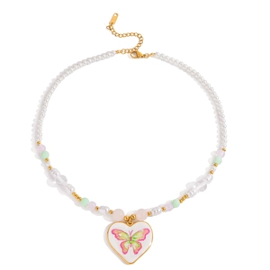 Collier de perles fantaisie avec pendentif cœur et papillon sur fond blanc immaculé