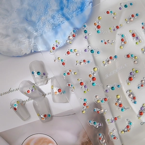 Detailed view of colorful rhinestones and silver embossed DIY nail art stickers