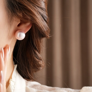 Close-up of model wearing elegant large mauve pink pearl earrings with strong luster