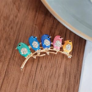 Macro detail of bird brooch with colorful enamel finish and sparkling crystal accents