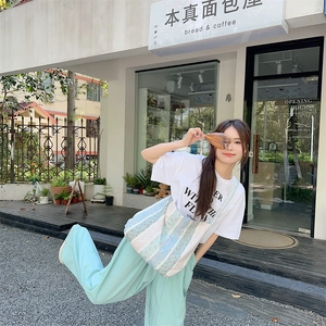 Floral patchwork canvas shoulder bag shown in a casual lifestyle streetwear style