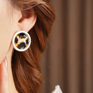 Retro leopard print round stud earrings with faceted resin finish on female model