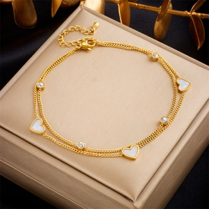 Gold double-layer anklet with white heart pendant and sparkling crystals on jewelry box