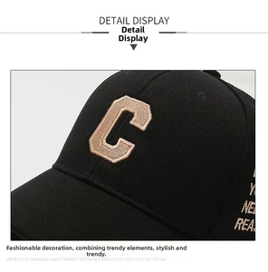 Close-up of premium black cotton fabric with beige letter C embroidery on baseball cap