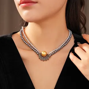 Vintage double-layer pearl necklace with sun-shaped gold pendant and colorful rhinestones