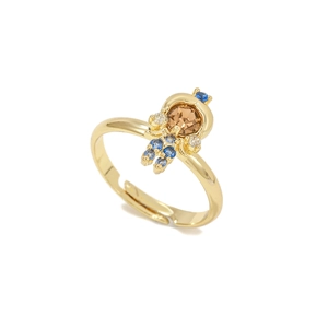 Dettaglio anello astronauta dorato con micro-set di zirconi blu e bianchi