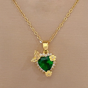 Macro view of heart-shaped green gemstone with gold butterfly and floral diamond details
