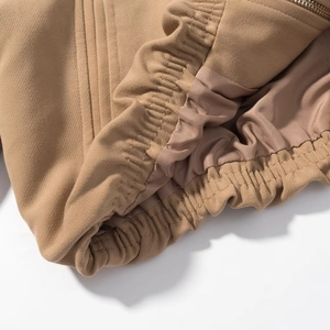 Détail du blouson zippé kaki avec ourlet élastique et texture de tissu en sergé premium