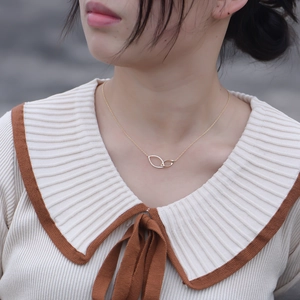 Minimalist gold double ring necklace with sparkling diamonds worn by a female model