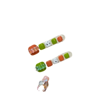 Press-on toenails with summer color-block design in orange and green with 3D relief