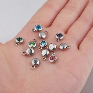 Macro shot of 6.5mm stainless steel birthstone charms with colorful inlaid gems