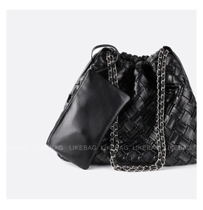 Detail of black woven leather tote bag with elegant silver chain and matching pouch