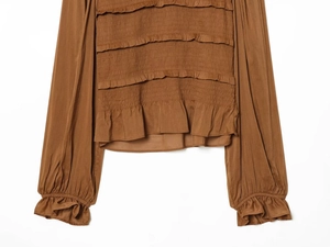 Close-up of caramel brown smocked bodice with layered ruffle details and textured fabric