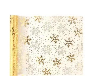 Close-up of translucent white mesh table runner with gold snowflakes and metallic dots