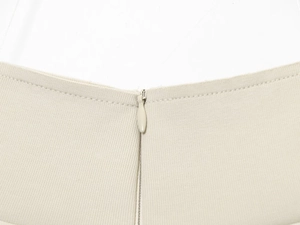 Macro shot of invisible zipper and ribbed knit fabric texture on beige casual set