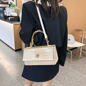 Detail of stone pattern texture and bamboo handle on stylish off-white shoulder bag