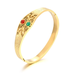 Irregular geometric gold titanium bracelet featuring cat's eye stones in an open-cuff style