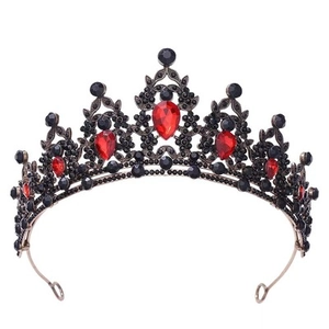 Macro detail of Baroque gold leaf crown with red gemstones and black crystal inlay
