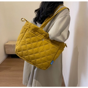 Detail view of yellow quilted tote bag showing large diamond stitching and soft fabric