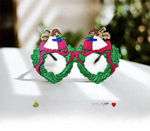 Dettaglio di occhiali ghirlanda di Natale glitter verdi con fiocchi rosa e angelo