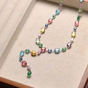 Detail of colorful oval-cut crystals on a silver necklace in a jewelry tray display