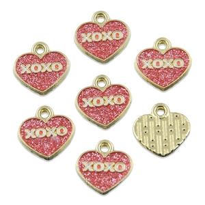 Macro view of heart pendants with XOXO engraving and red glitter for DIY jewelry making