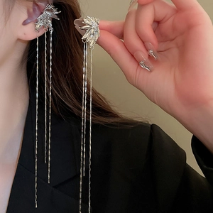 Close-up of sparkling zircon leaf tassel earrings worn with a black blazer for a chic look