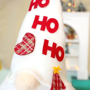Macro view of plush Christmas gnome with HO HO HO embroidery and festive tree detail