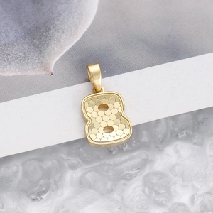 Macro detail of number 8 pendant with golden honeycomb texture and polished finish