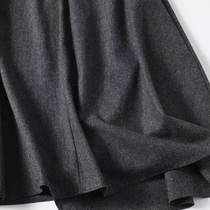 Gros plan détaillé sur un tissu tissé épais gris foncé avec texture et plis fluides