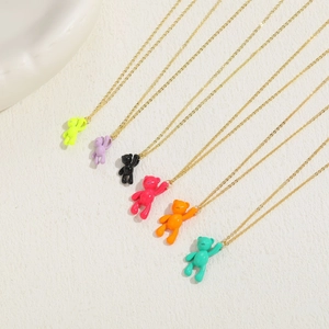 Detailed close-up of vibrant enamel bear pendants on thin gold chains in six colors