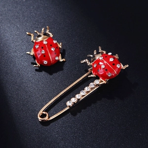 Golden ladybug brooch set with red enamel wings and sparkling crystal rhinestones