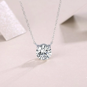 Macro shot of 1 carat moissanite pendant with four-prong setting on silver chain