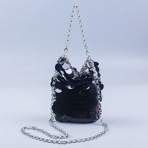 Detailed view of black oversized sequins and silver metal chain on mini crossbody bag