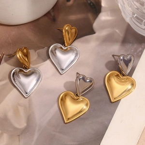 Detail of double heart earrings in mixed gold and silver finishes on a fashion background