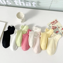 Detailed view of candy-colored low cut socks neatly arranged on a bright windowsill