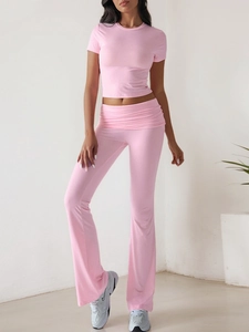 Pink slim-fit two-piece set featuring a short-sleeve crop top and high-waisted flare pants