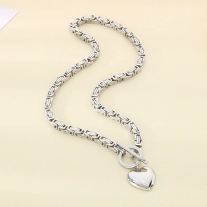Detail of silver stainless steel Byzantine chain necklace with heart pendant and toggle clasp