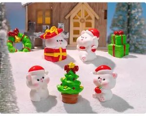 Miniature Christmas resin figurines including bears and trees on a snowy backdrop