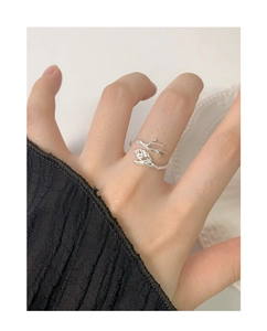 Macro shot of silver branch and leaf ring showing intricate textures on model's hand