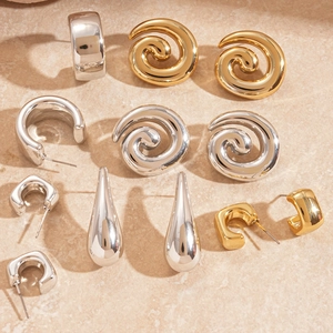 Polished gold and silver geometric acrylic earrings in spiral and teardrop shapes