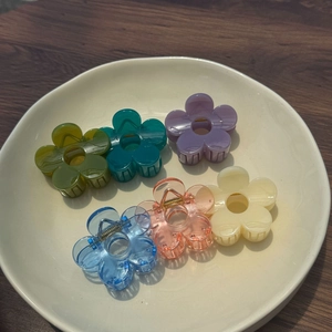 Pinces à cheveux en forme de fleur en 6 couleurs pastel sur un plateau en céramique