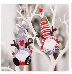 Detail of wooden Christmas gnome ornaments with antlers and Welcome text hanging on a white branch