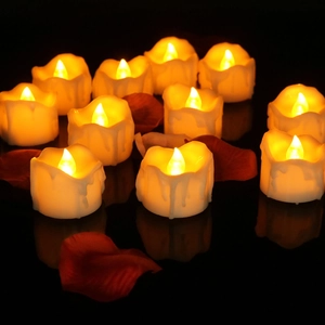 Romantic LED tea lights with warm yellow glow and rose petals on dark surface