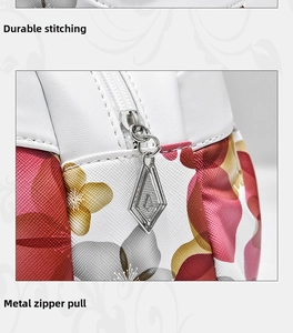 Detail of sturdy stitching and hardware zipper pull on floral print leather tote bag
