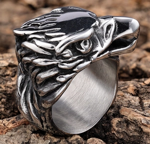 Macro detail of retro eagle head ring with vintage finish on natural wood background