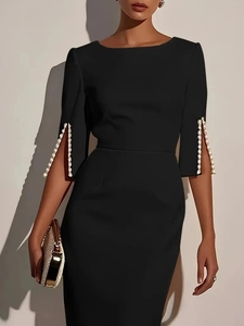 Close-up of elegant black midi dress featuring pearl-beaded split sleeves and fine fabric